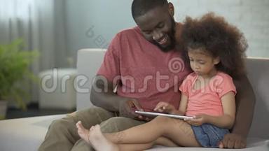 爸爸和女儿一起玩平板电脑的教育游戏